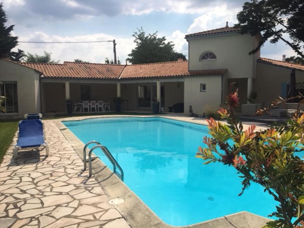 a swimming pool in front of a house at Villa de 4 chambres avec piscine partagee a Meschers sur Gironde in Meschers-sur-Gironde