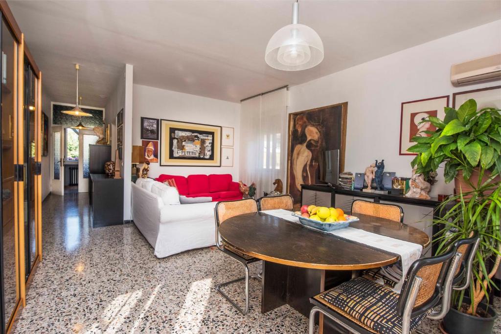 a living room with a table and a red couch at CASA D'ARTISTA in Cavallino-Treporti