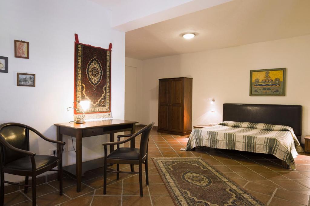 sypialnia z łóżkiem, biurkiem i krzesłami w obiekcie Villa Piersepp B&B w mieście Trappitello