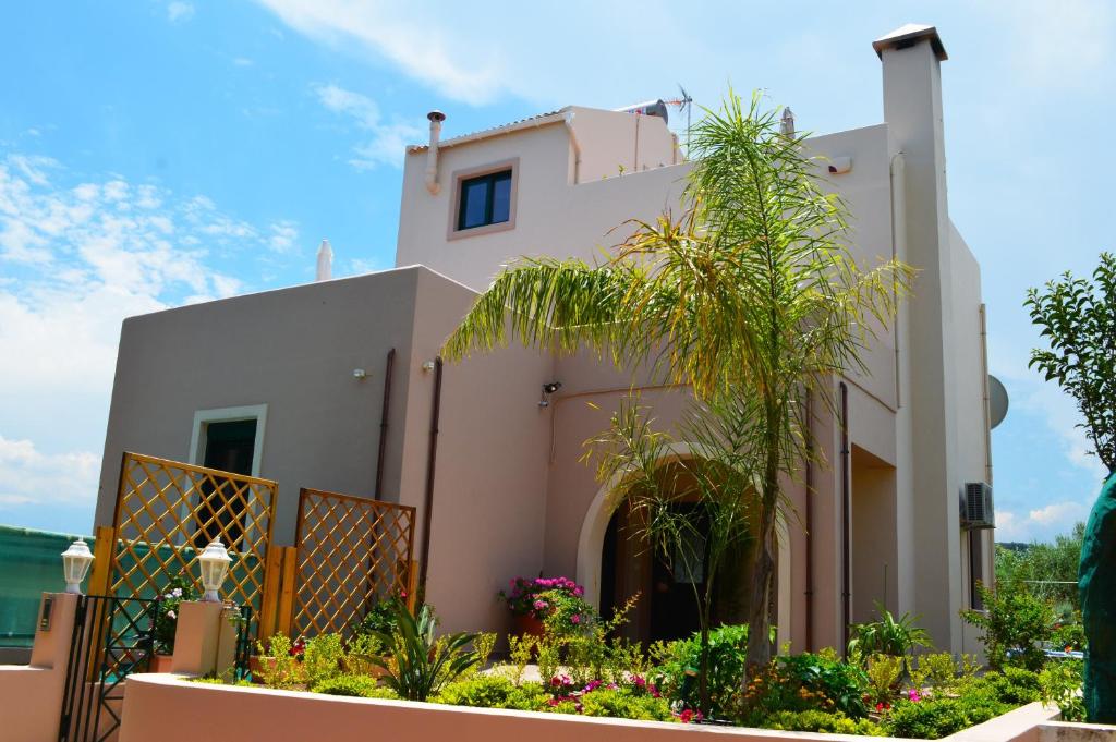 una casa con una palmera delante de ella en Belle Verte Villa Maleme, en Máleme