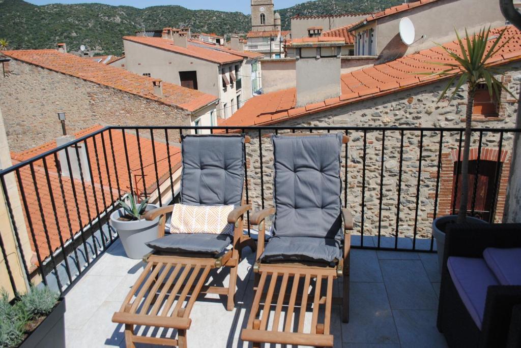 2 Stühle auf dem Balkon in der Unterkunft Agréable maison de village avec terrasse in Vinça