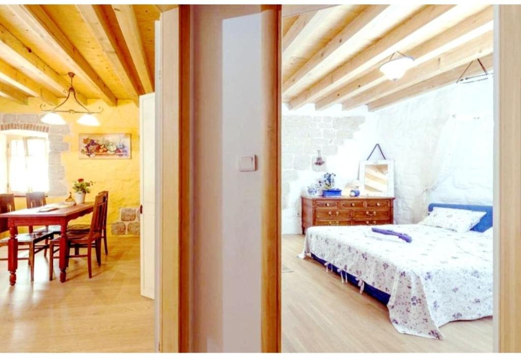 um quarto com uma cama e uma mesa de jantar em HVAR HEART HERITAGE STONE HOUSE 2 floors, up to 6 persons em Stari Grad