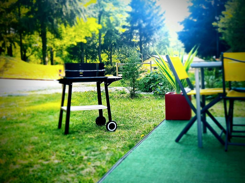 a barbecue grill sitting on the grass in a yard at Le verdoyant in Saint-Chéron