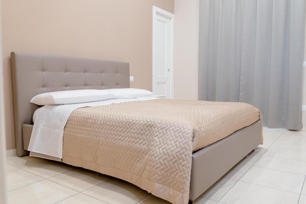 a white bedroom with a large bed with white walls at Carmela's Guest House Pompeii in Pompei