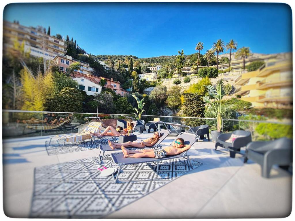 a group of people laying in chairs on a patio at Le Vallaya Suites & Spa in Menton
