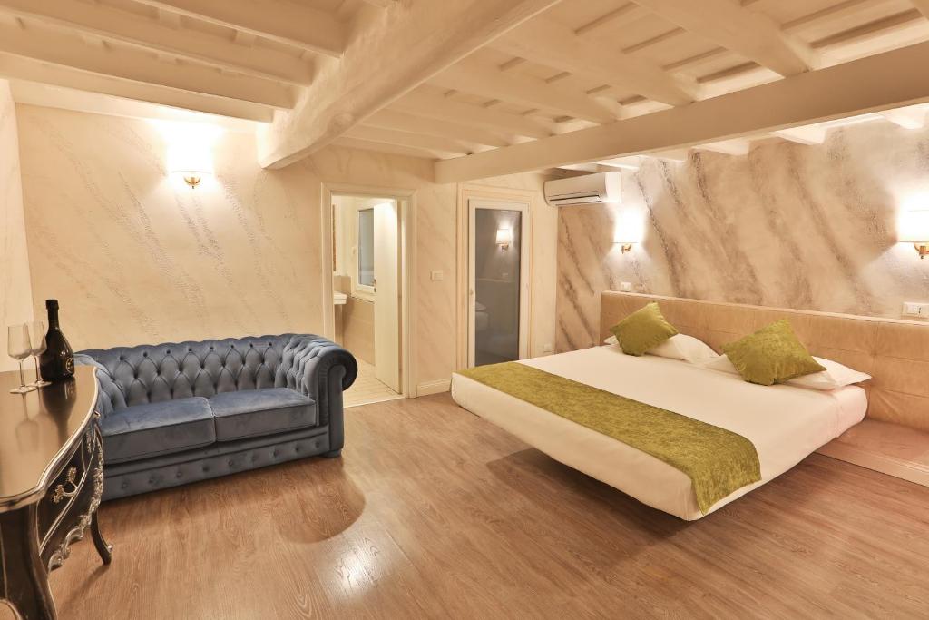 1 dormitorio con 1 cama y 1 sofá azul en Grottini Luxury Suites ~ Pantheon en Roma