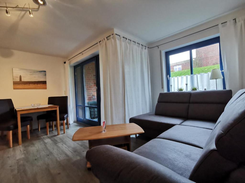 - un salon avec un canapé et une table dans l'établissement Strandlicht, à Horumersiel