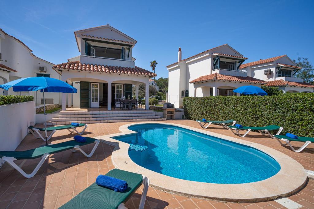 a house with a swimming pool in front of a house at Villa LAS MARINAS - 3, con piscina privada y a 5 minutos de la playa in Punta Grossa