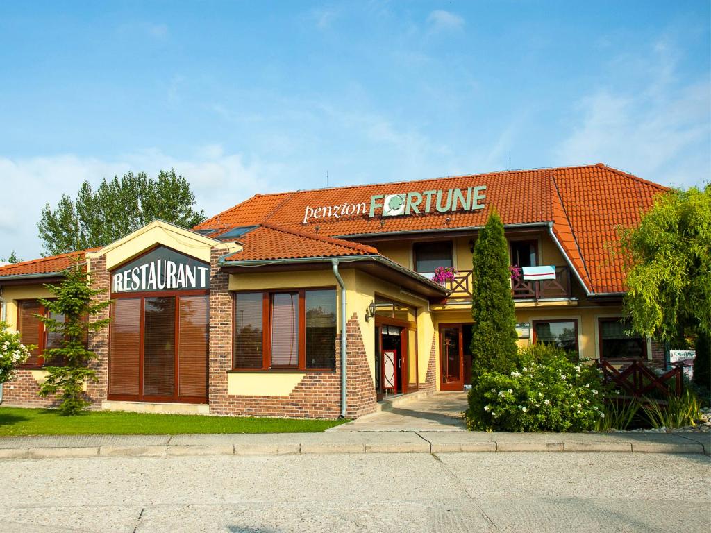 a building with a sign that reads reputation furniture at Penzion Fortune in Dunajská Streda