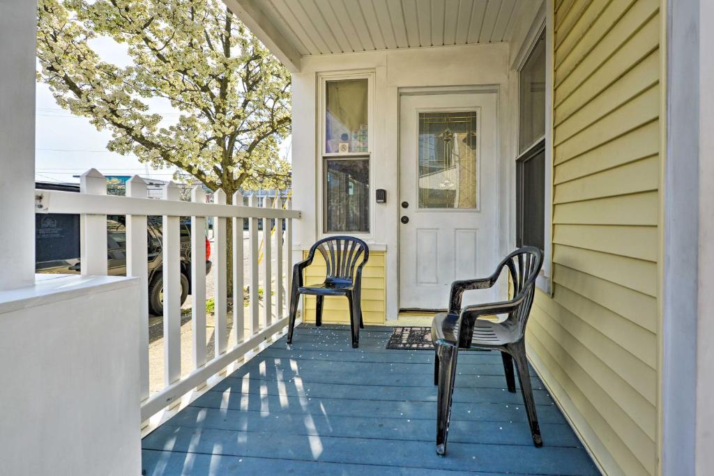 two chairs sitting on the front porch of a house at Wildwood Apartment - Porch and Enclosed Sunroom! in Wildwood