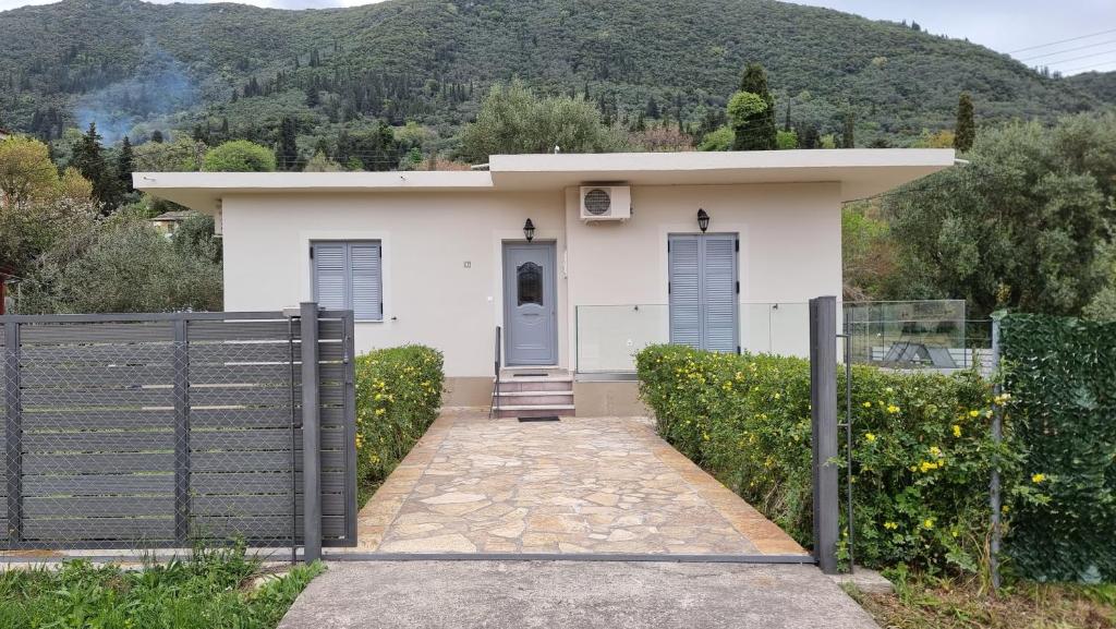 a white house with a gate and a fence at Villa Kipourio in Ipsos