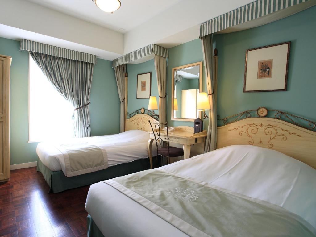 فندق Monterey Lasoeur Ginza في طوكيو: غرفة فندقية بسريرين ومرآة