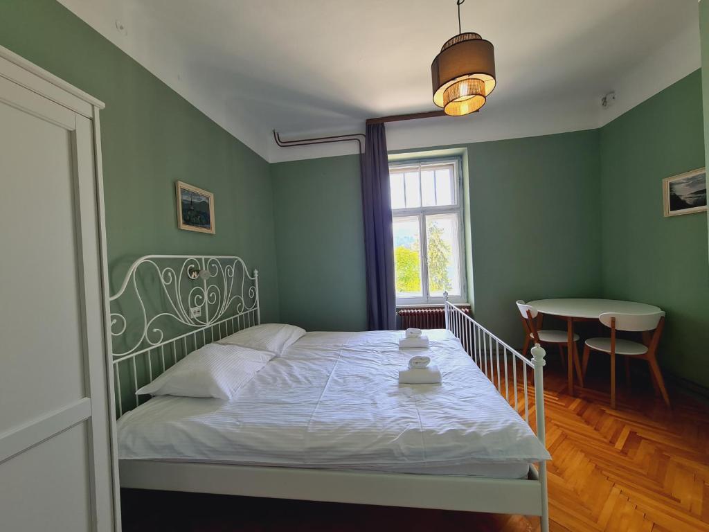 1 dormitorio con cama, mesa y ventana en Vila Gorenka, en Bled
