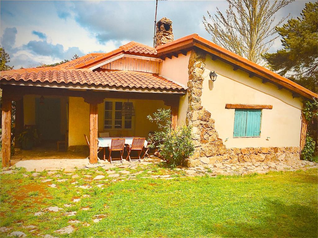 una pequeña casa amarilla con una mesa delante en LA MALINCHE, en Segovia