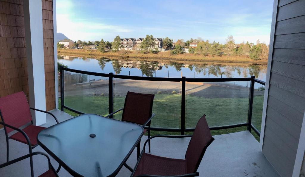 a balcony with chairs and a view of a lake at Riverview Retreat in Seaside