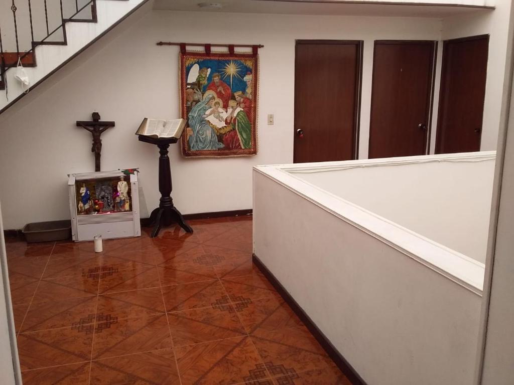 una habitación con una cruz y una pintura en la pared en Habitación con baño privado cerca al aeropuerto, en Bogotá