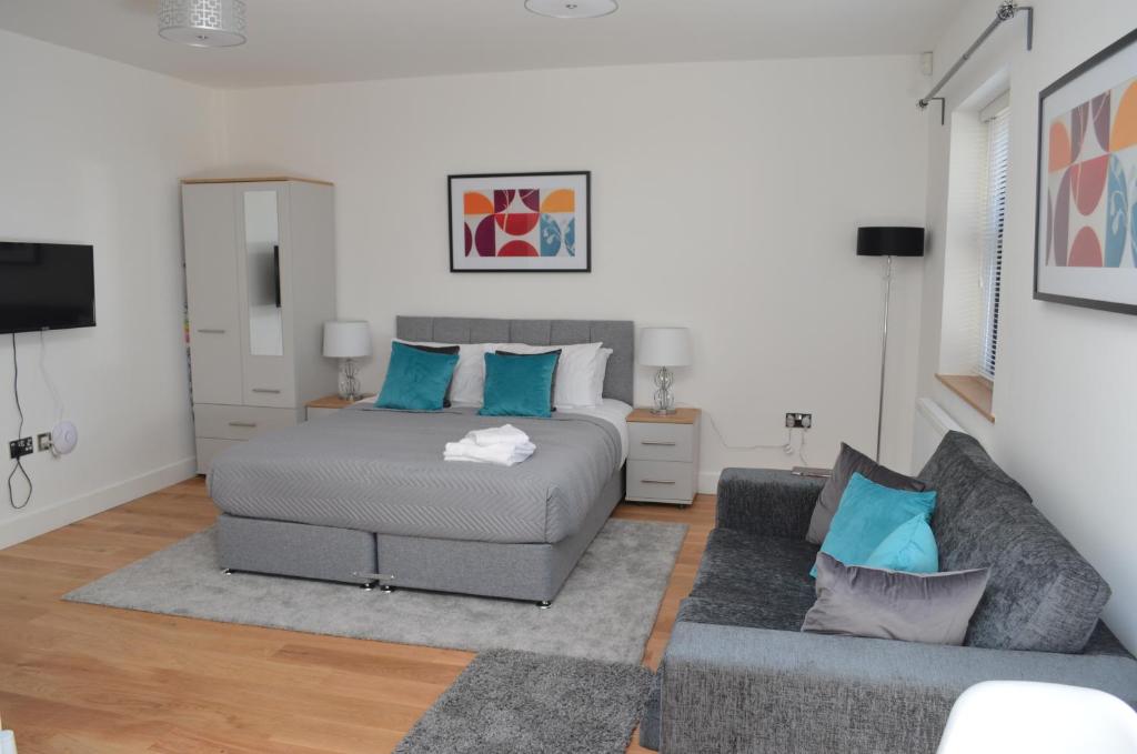 een slaapkamer met een bed en een bank bij High Spec Luxury Studio Apartment in Sydenham in Sydenham