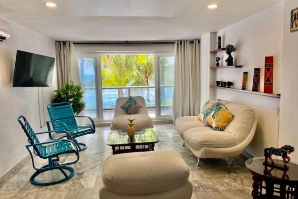 圣安德烈斯Apartamento en San Andrés Frente al Mar en Sun Rise的客厅配有家具和大窗户