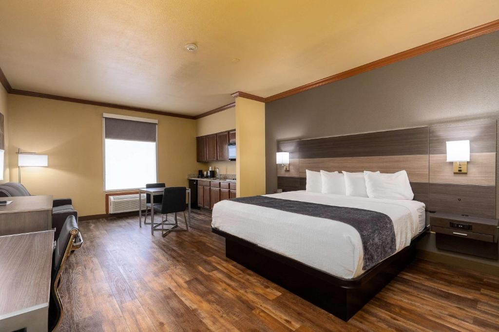 a hotel room with a large bed and a kitchen at Best Western Plus Portland in Portland