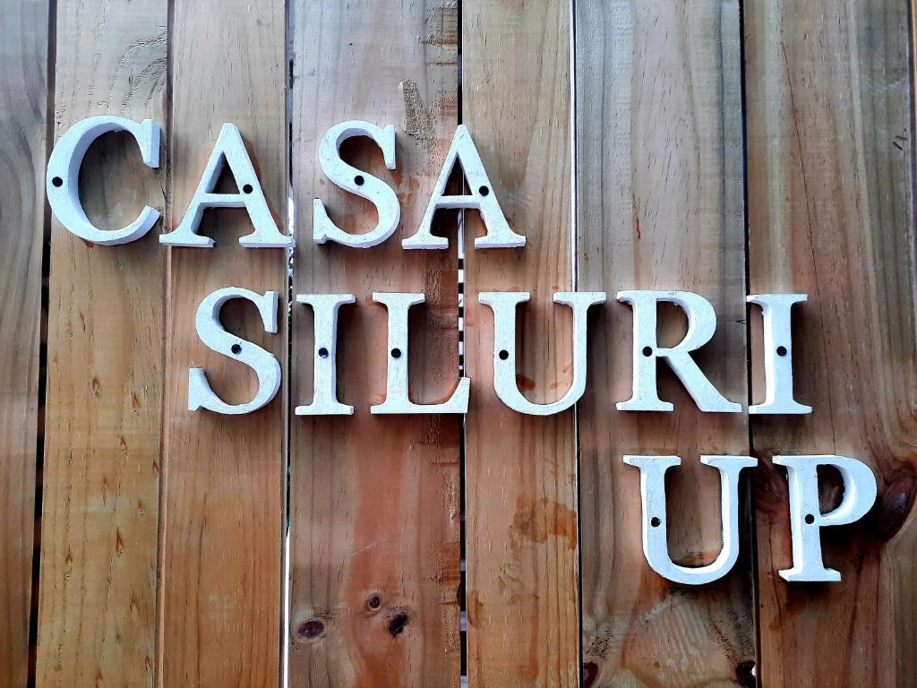 a sign that says casa shiner up on a wooden wall at Casa SILURI UP in Santa Teresa Beach