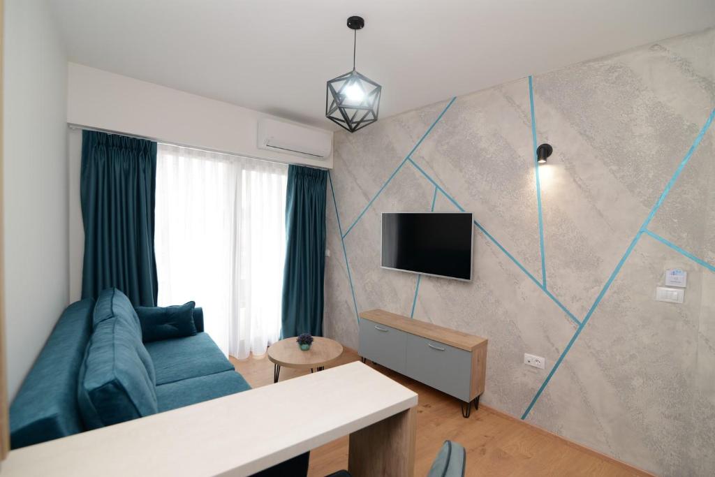 a living room with a couch and a tv on a wall at NOCE Apartments - Premium Lake View in Ohrid