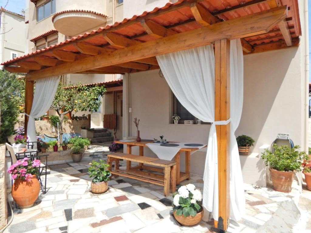 an outdoor patio with a wooden pergola at Psaromoura Apartment in Agia Pelagia