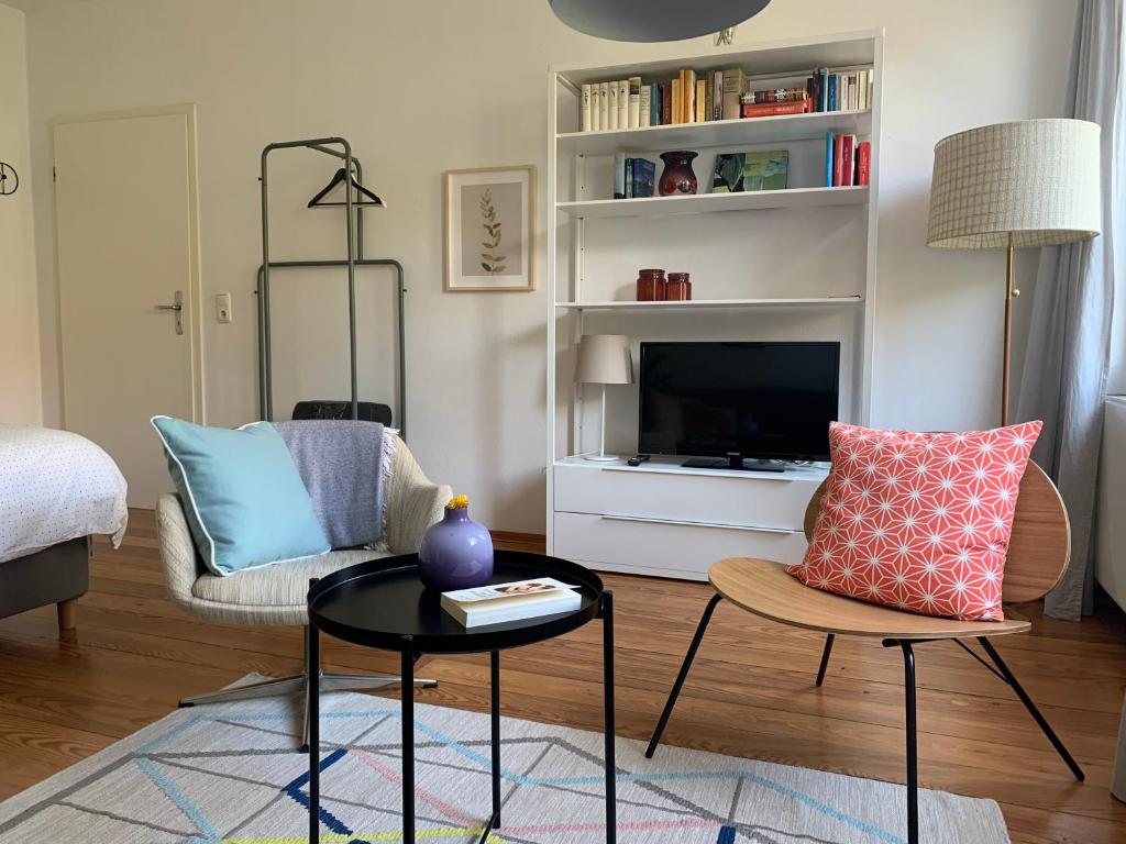 a living room with a table and a tv at charmant Leben im Textilviertel_zentral & ruhig in Augsburg