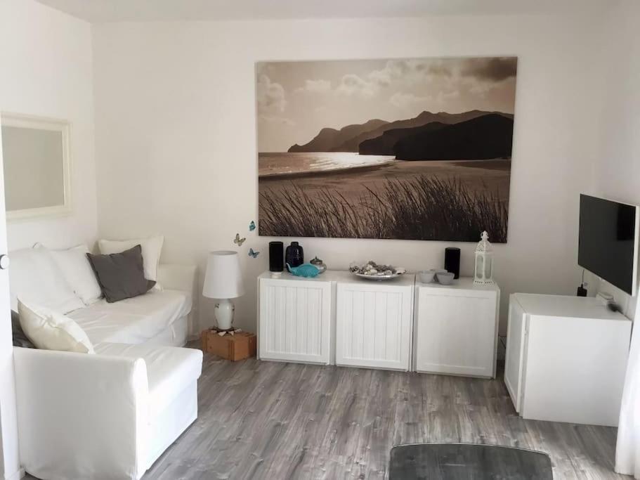 uma sala de estar com mobiliário branco e uma pintura na parede em Lovely lake wiev&pool em Malcesine