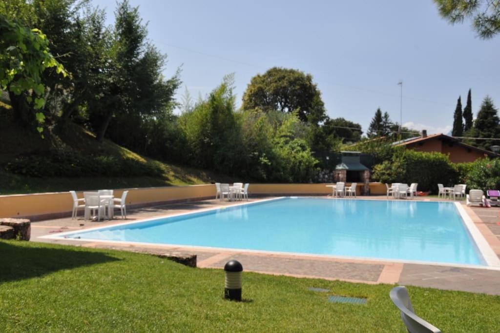 duży basen z krzesłami na dziedzińcu w obiekcie Lovely lake wiev&pool w mieście Malcesine
