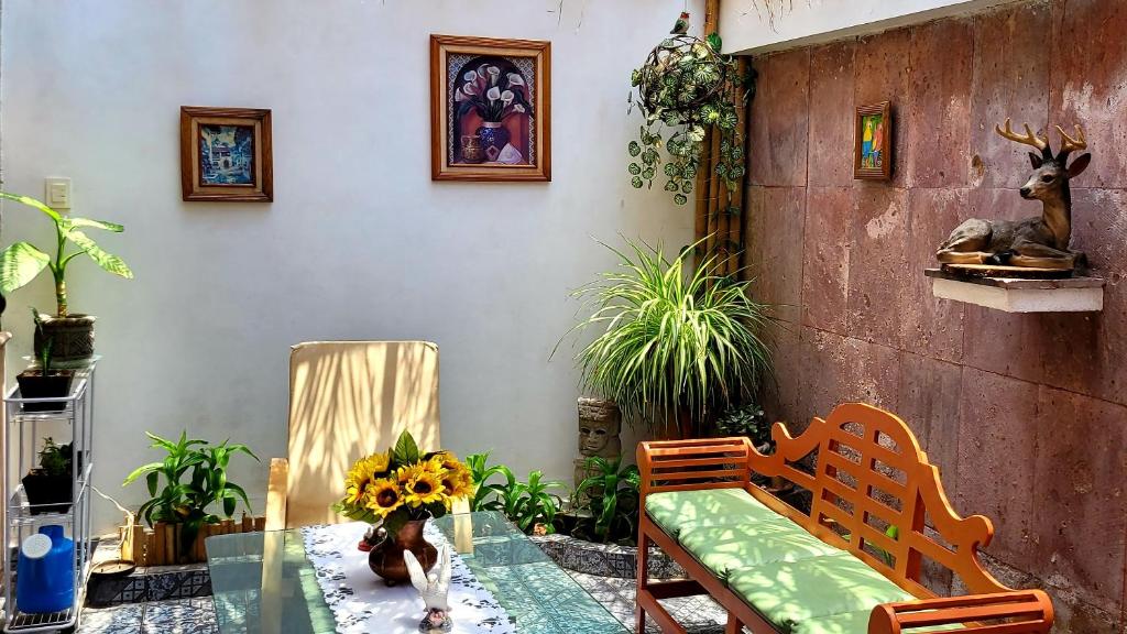 een tafel met een vaas met zonnebloemen erop bij Casa Q BnB in Mexico-Stad