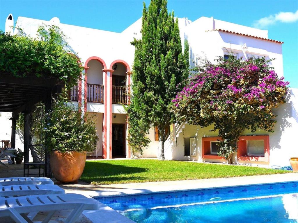 una casa con piscina frente a un edificio en Exclusive holiday home in Siesta with private pool en Santa Eularia des Riu
