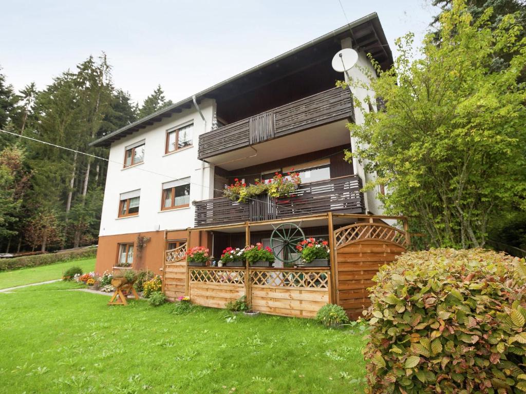 uma casa com uma varanda com flores em Cosy and spacious apartment with balcony in the Black Forest em Waldachtal