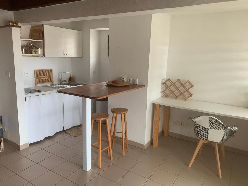 a kitchen with a wooden table and stools in it at The N’house in Kourou