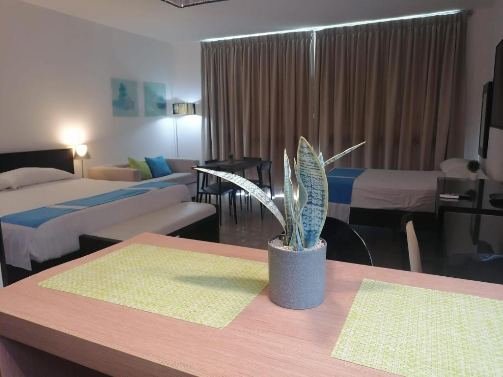 a hotel room with two beds and a plant on a table at Playa Blanca Town Center B in Playa Blanca