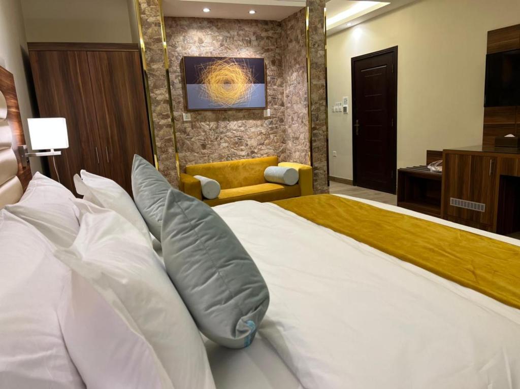 um quarto com uma cama grande e almofadas brancas em Moments Hotel em Jeddah