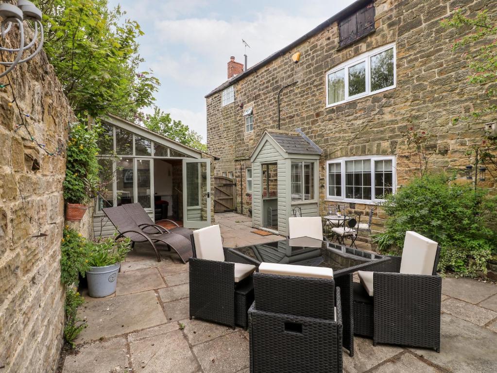 an outdoor patio with a table and chairs at Christmas Cottage in Alfreton