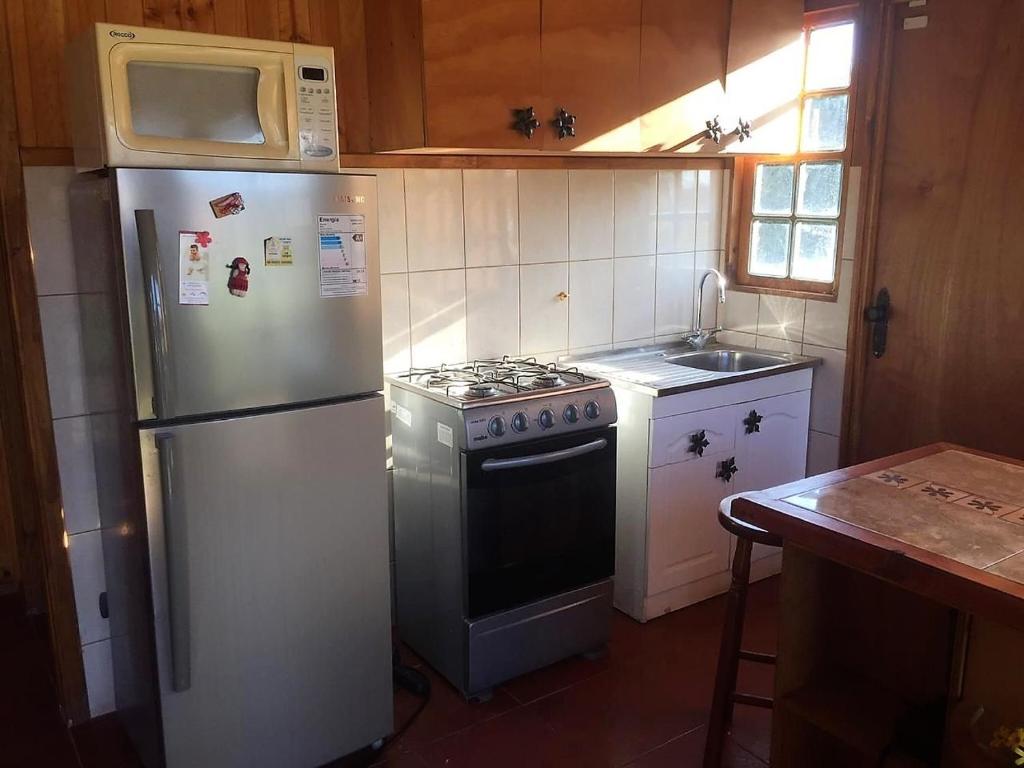 een keuken met een koelkast, een fornuis en een magnetron bij Gran Parcela Monte de Olmue in Olmué