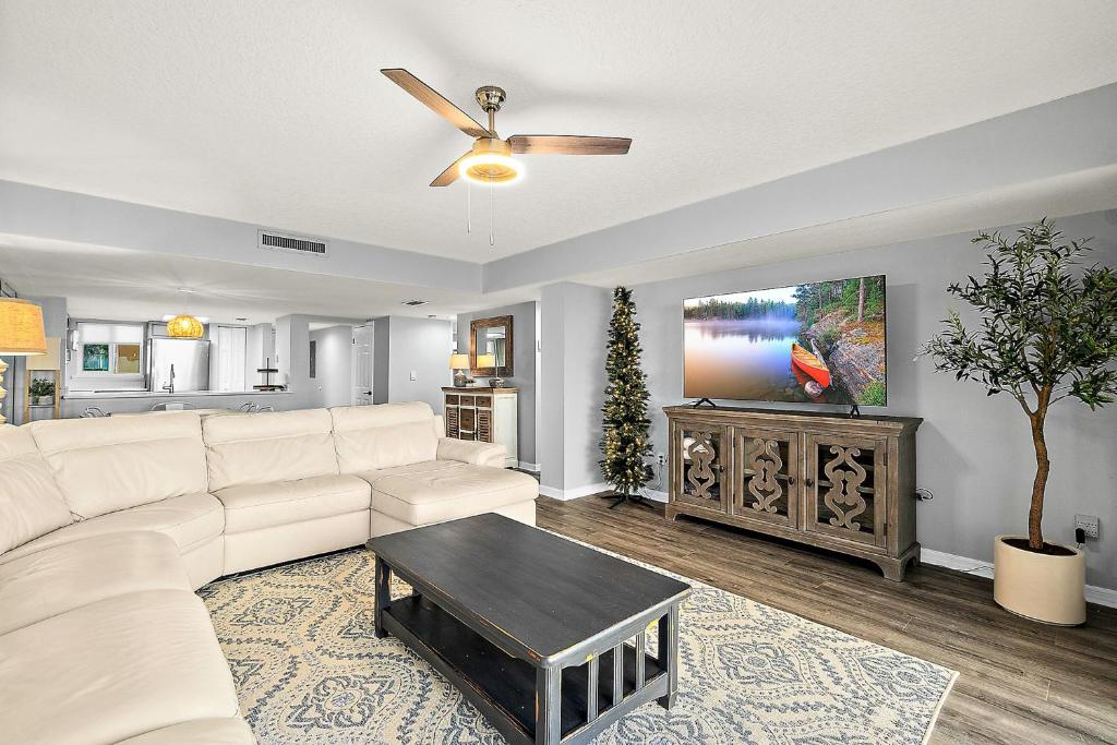 uma sala de estar com um sofá branco e uma televisão em Pier Point South 37 em St. Augustine