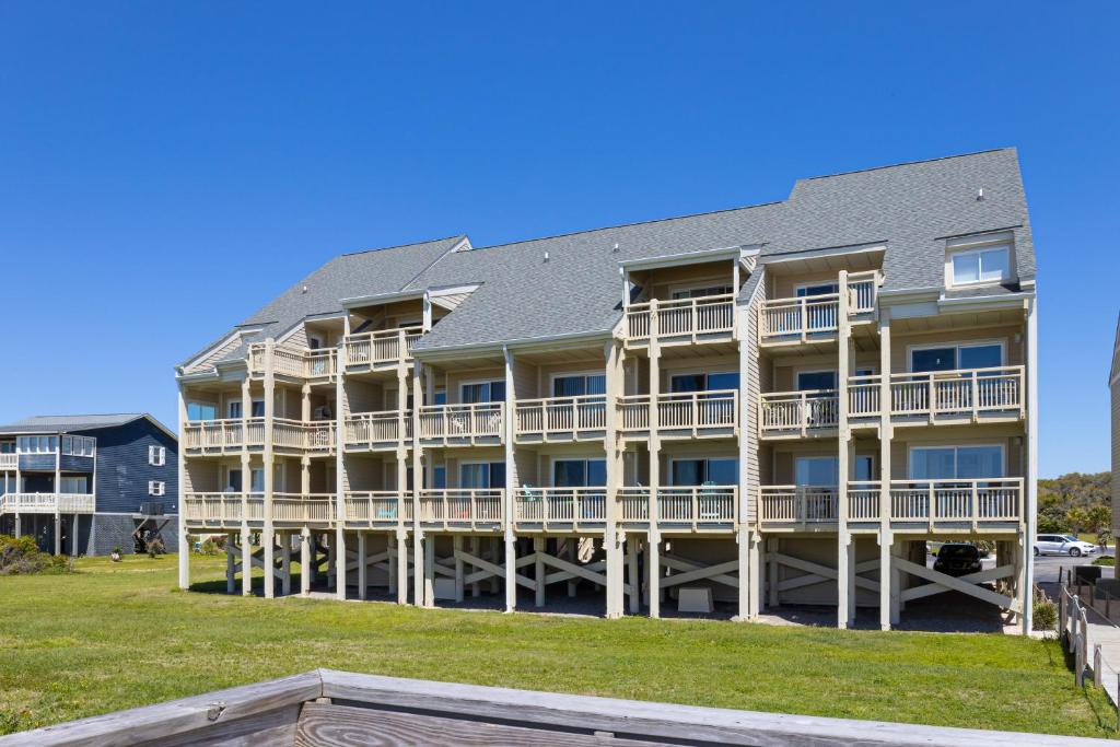 duży apartamentowiec z balkonem i dziedzińcem w obiekcie Three Brothers w mieście Oak Island