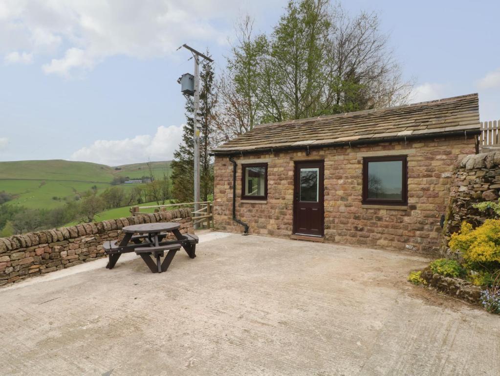 una mesa de picnic frente a un edificio de ladrillo en The Piggery en Macclesfield