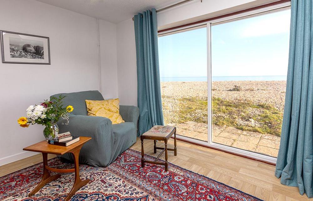 a living room with a couch and a large window at Marie's Cottage, Pagham in Pagham