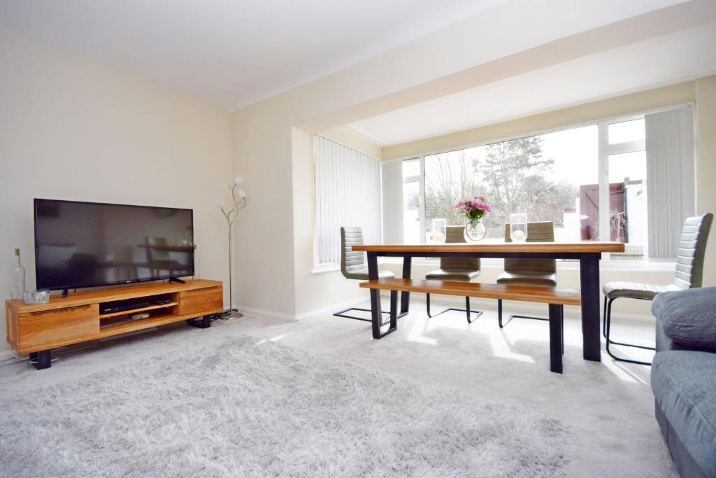 een woonkamer met een tafel en een televisie bij Bankside, Middleton in Middleton-on-Sea