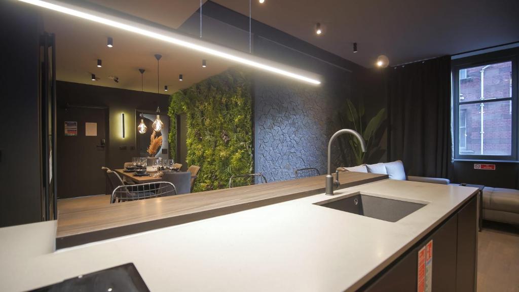 a kitchen with a sink and a dining room at Midnight by The Heim Residences in Manchester