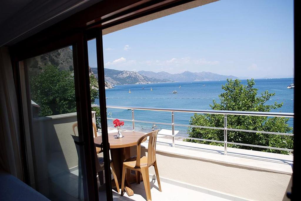 a balcony with a table and a view of the ocean at Can Apartments in Turunc