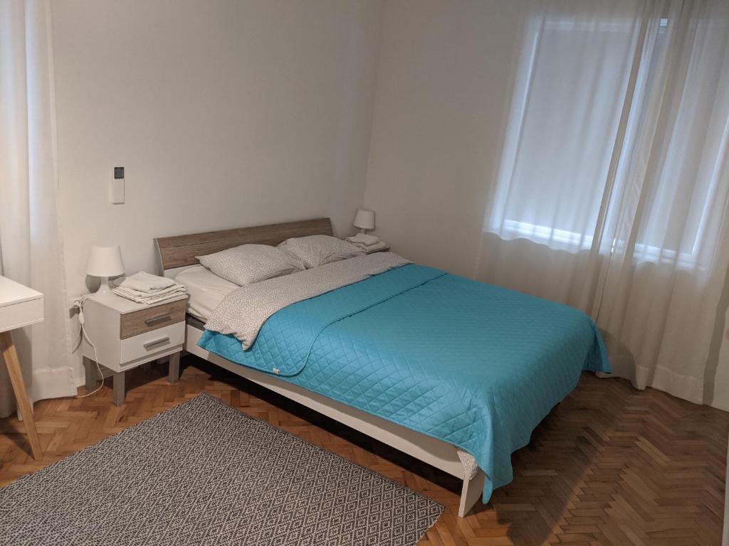 a small bedroom with a bed and a nightstand and a window at Small cozy apartment near the center of Plovdiv in Plovdiv