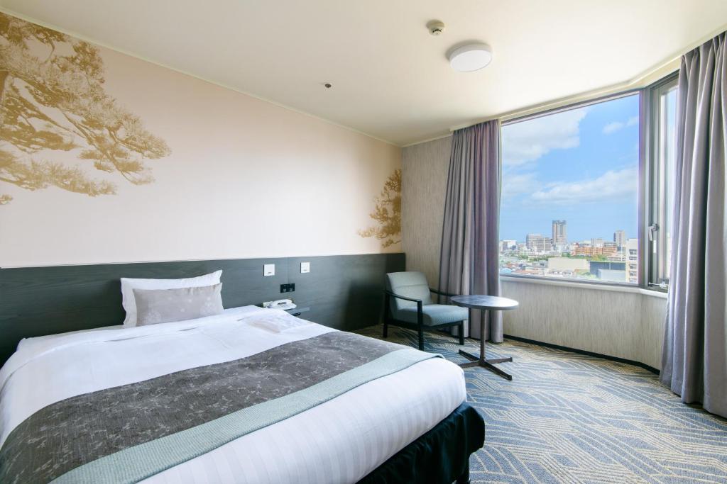 a hotel room with a bed and a large window at Kanazawa Tokyu Hotel in Kanazawa