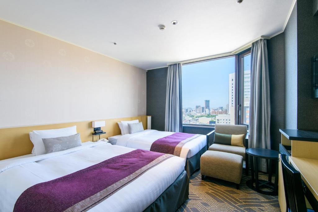 a hotel room with two beds and a window at Kanazawa Tokyu Hotel in Kanazawa