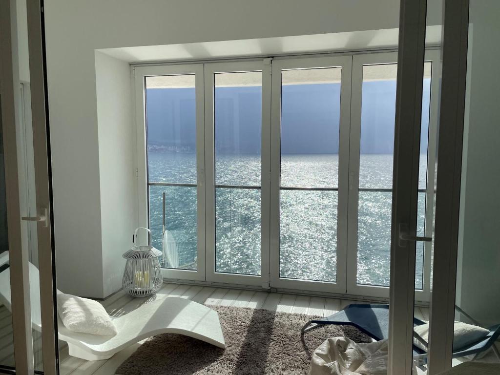 een kamer met een raam met uitzicht op de oceaan bij First row to the sea - Nautilus Deluxe Apartment in Opatija