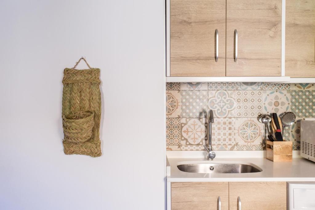 a kitchen with wooden cabinets and a sink at Mayor 7 by Seaward Suites in Villajoyosa