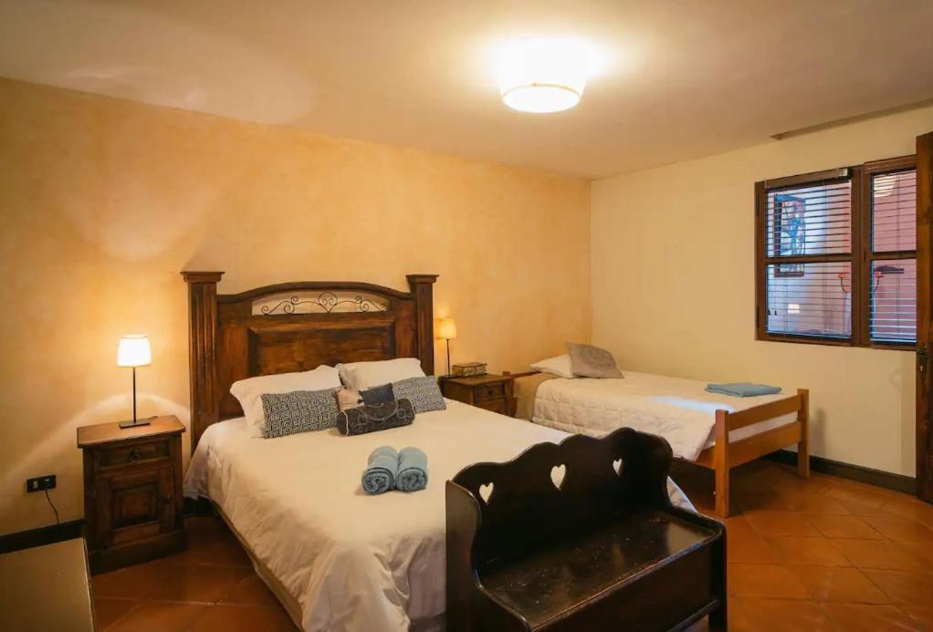 a bedroom with two beds and a chair in it at Villa Detalles in Antigua Guatemala